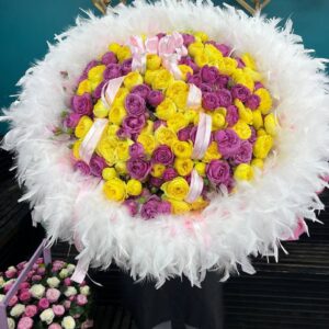 Букет жёлтых и фиолетовых роз с перьями